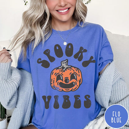 Comfort Colors tee in Flo Blue featuring retro style graphic with a smiling pumpkin and Spooky Vibes text