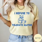 Comfort Colors tee in Butter featuring graphic style illustration of a raccoon holding a loaf of bread