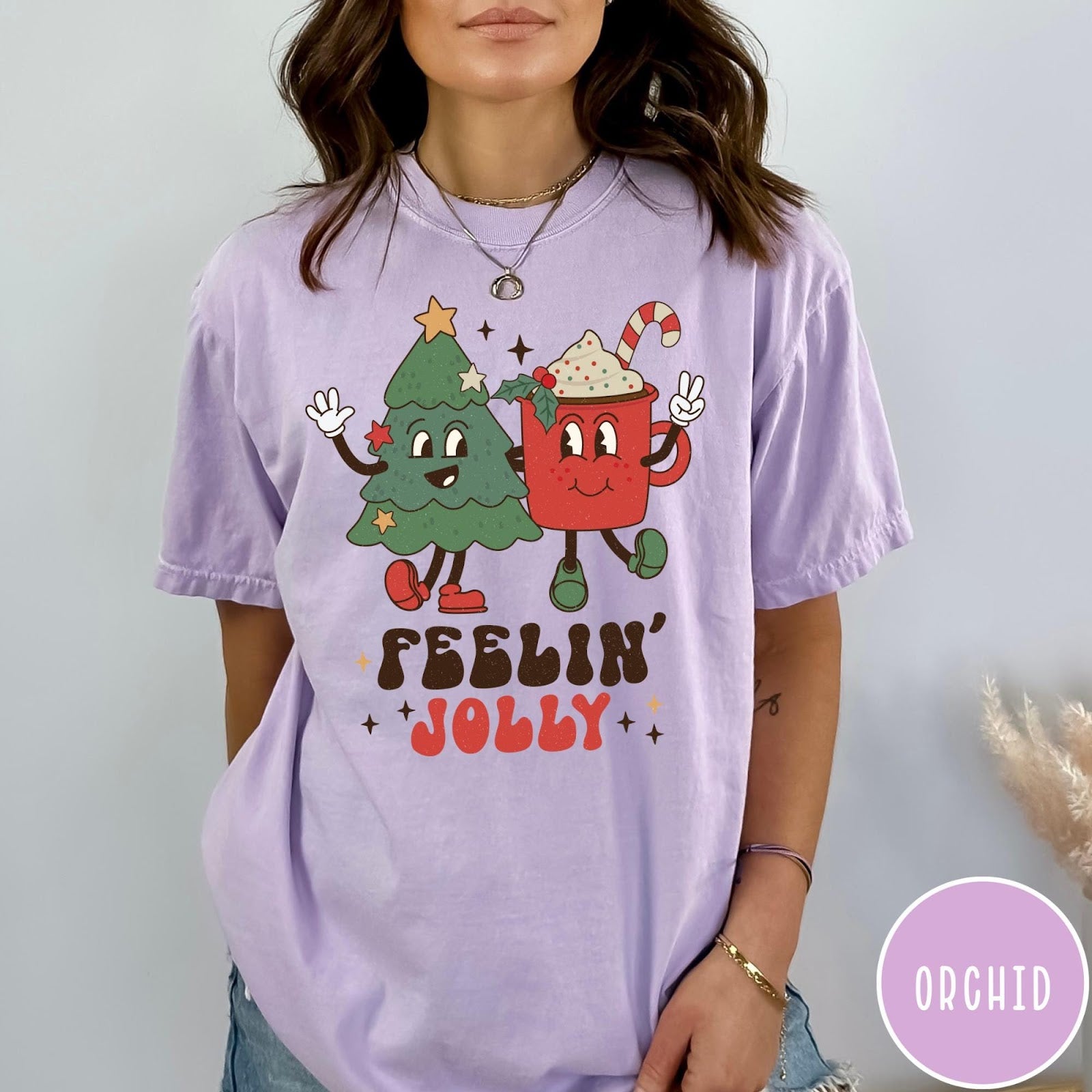 Comfort Colors tee in Orchid featuring retro style graphic of a cartoon Christmas tree and cocoa mug