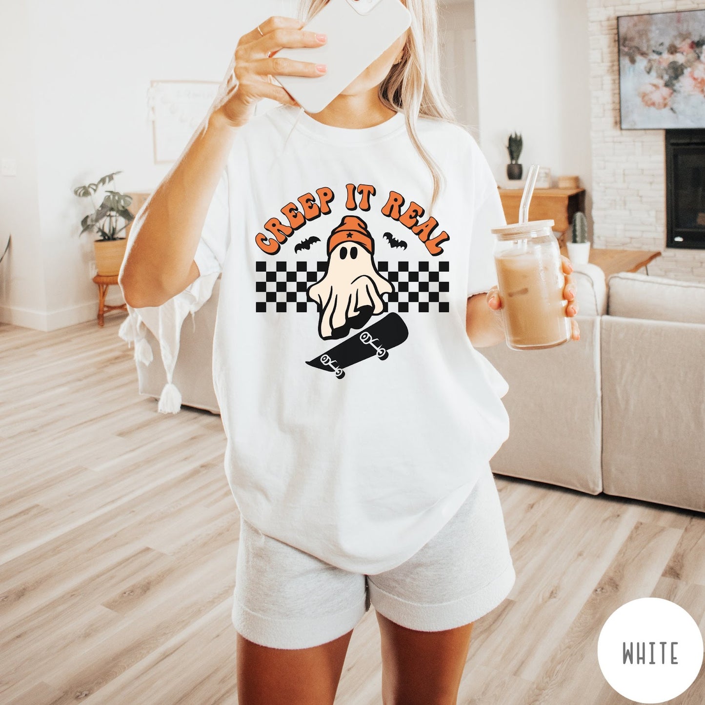Comfort Colors tee in White featuring retro style ghost graphic with skateboard and checkered background pattern