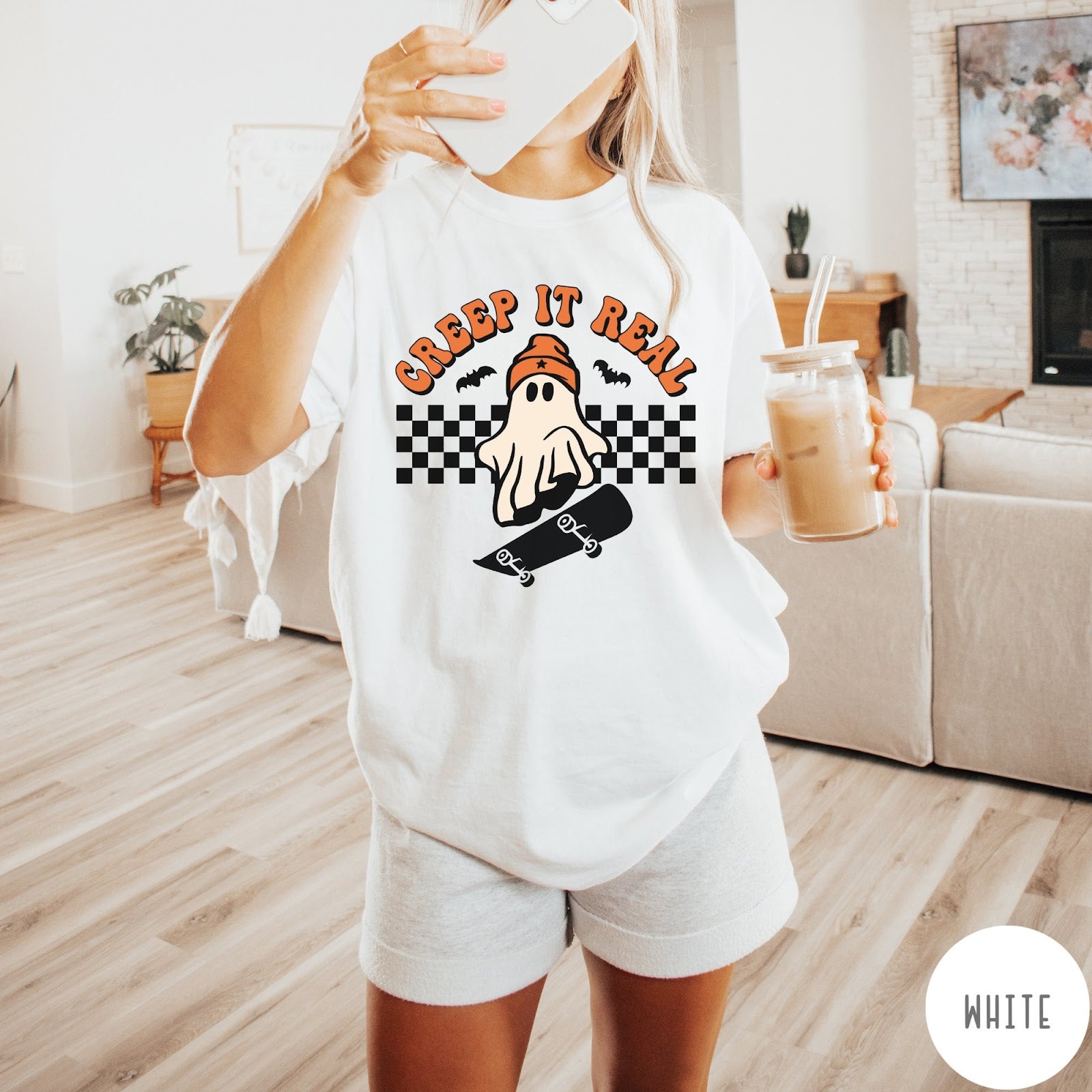 Comfort Colors tee in White featuring retro style ghost graphic with skateboard and checkered background pattern
