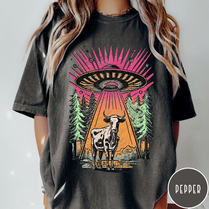 Comfort Colors tee in Pepper featuring graphic style cow being abducted by a UFO in the forest