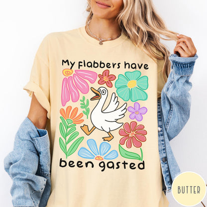 Comfort Colors tee in Butter featuring playful cartoon style graphic of a goose surrounded by colorful flowers