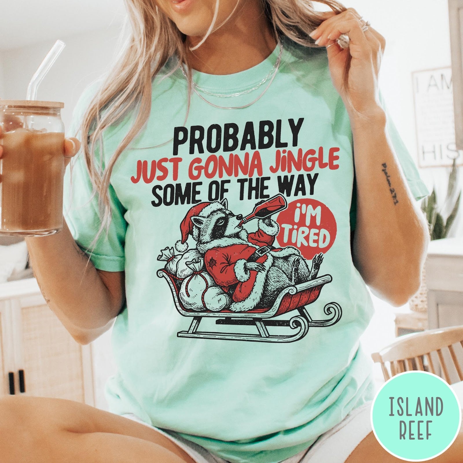 Comfort Colors tee in Island Reef featuring vintage style graphic of a tired raccoon in a Santa sleigh