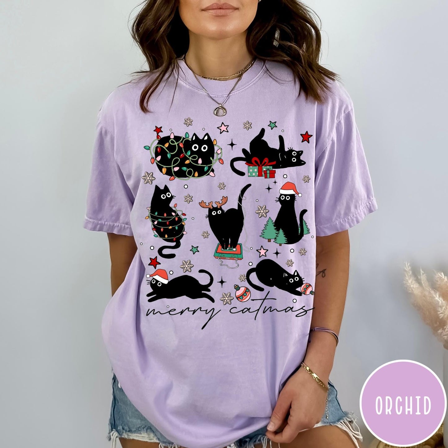 Comfort Colors tee in Orchid featuring festive holiday graphic with multiple black cats and Christmas elements