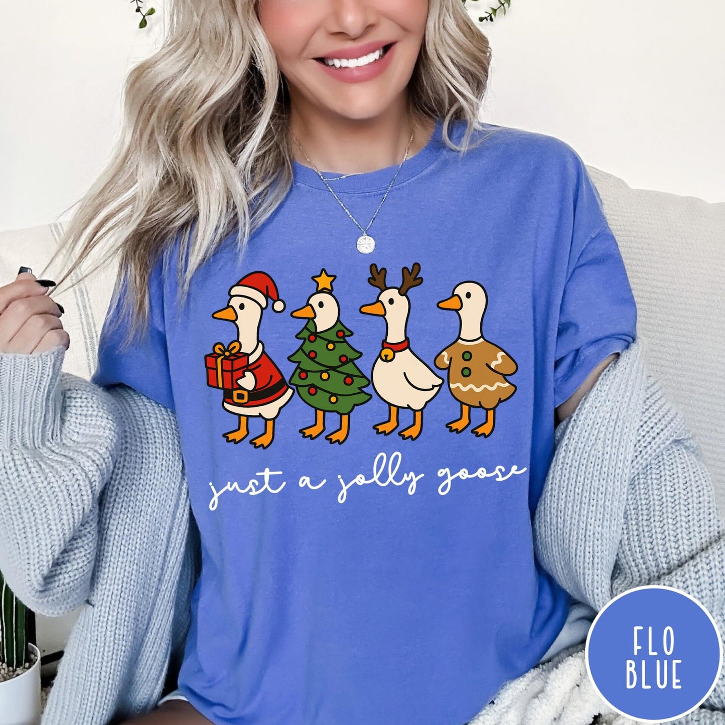 Comfort Colors tee in Flo Blue featuring festive geese graphic with Santa, Christmas tree, reindeer, and gingerbread goose designs