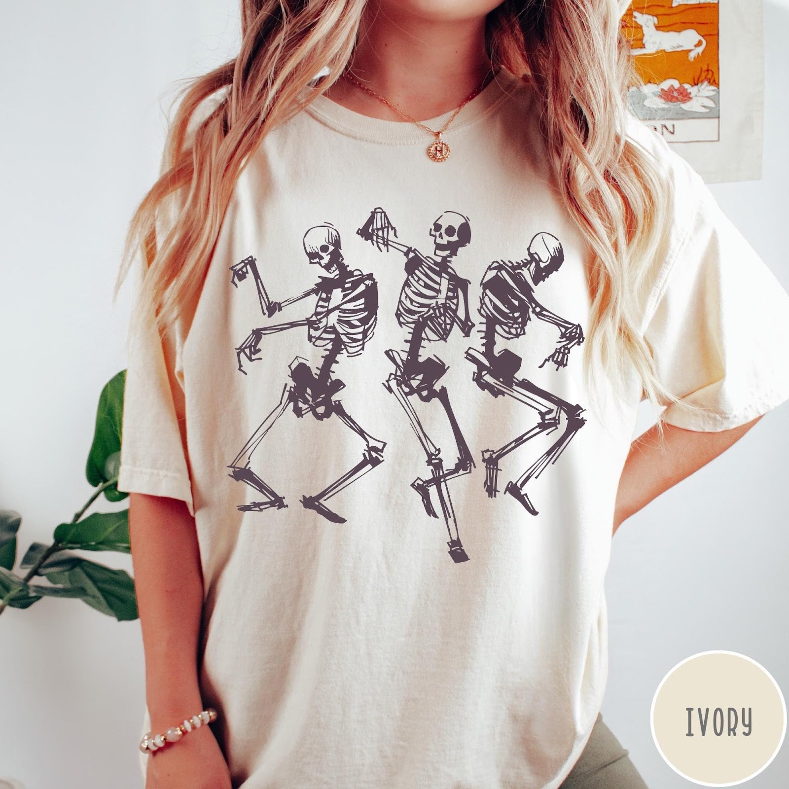 Comfort Colors tee in Ivory featuring dancing skeletons graphic illustration on the front of the shirt
