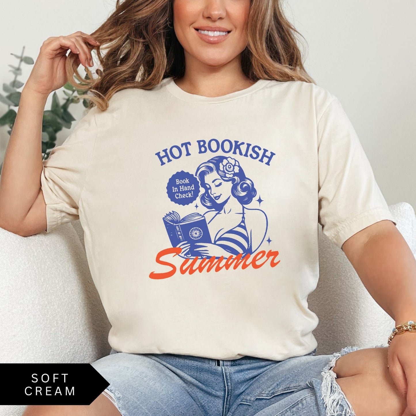 Comfort Colors tee in Soft Cream featuring pinup girl reading a book graphic design with blue and orange ink