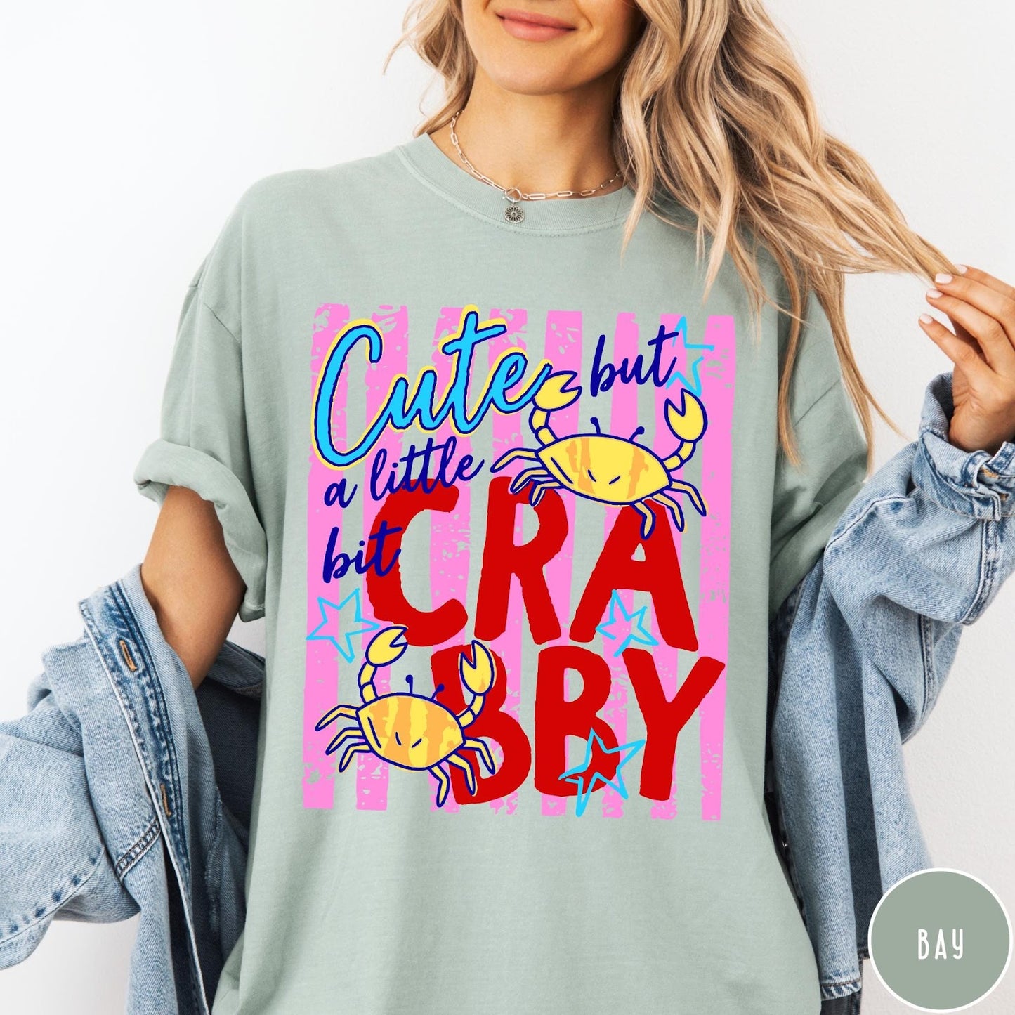 Comfort Colors tee in Bay featuring playful graphic text and yellow crab illustrations with pink stripes