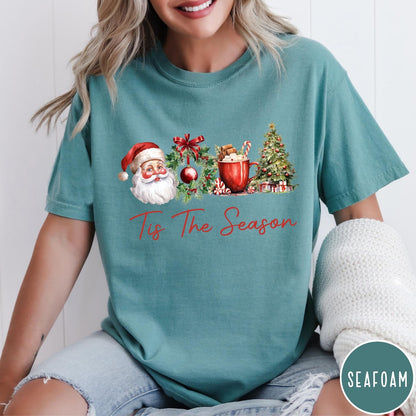 Comfort Colors tee in Seafoam featuring holiday design with Santa, wreath, hot cocoa, and Christmas tree graphic