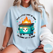 Comfort Colors tee in Chambray featuring cartoon style graphic of a smiling dumpster fire with text