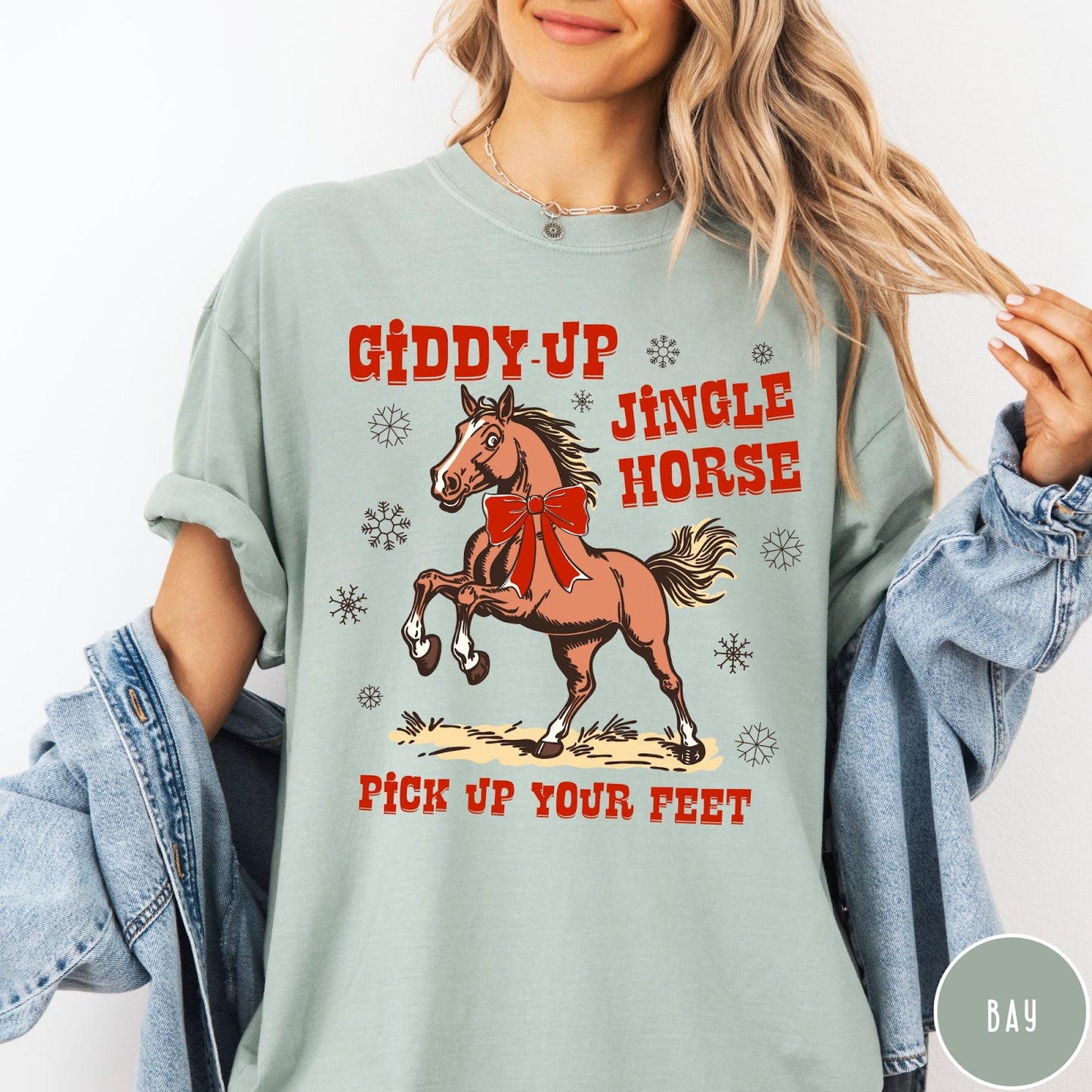 Comfort Colors tee in Bay featuring festive holiday graphic with a prancing horse wearing a red bow