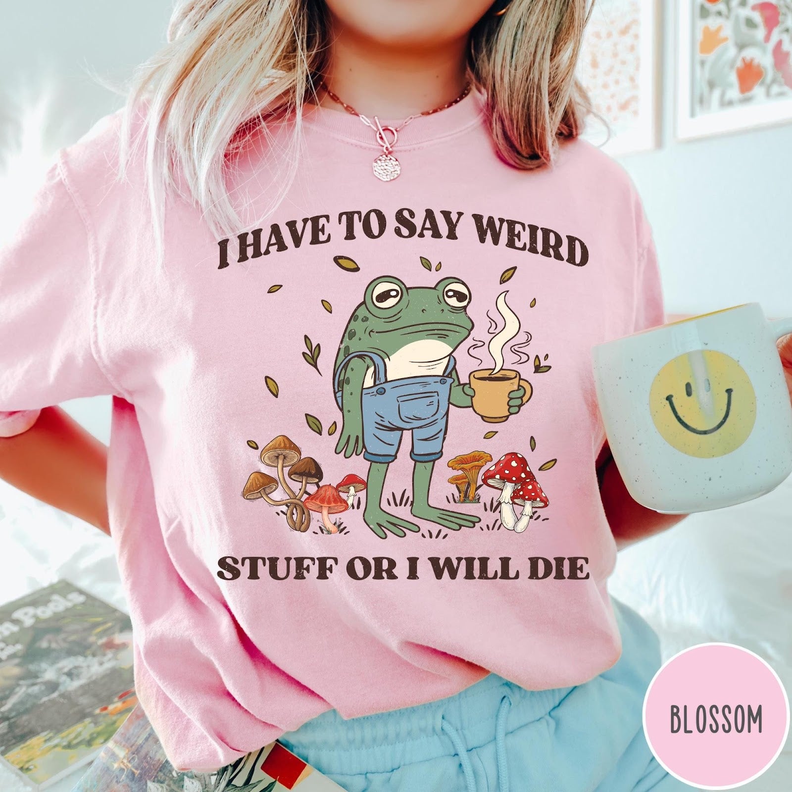Comfort Colors tee in Blossom featuring cartoon style frog wearing overalls holding a coffee mug with mushrooms