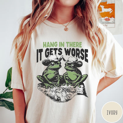 Comfort Colors tee in Ivory featuring vintage style graphic of two frogs wearing cowboy hats on leaf