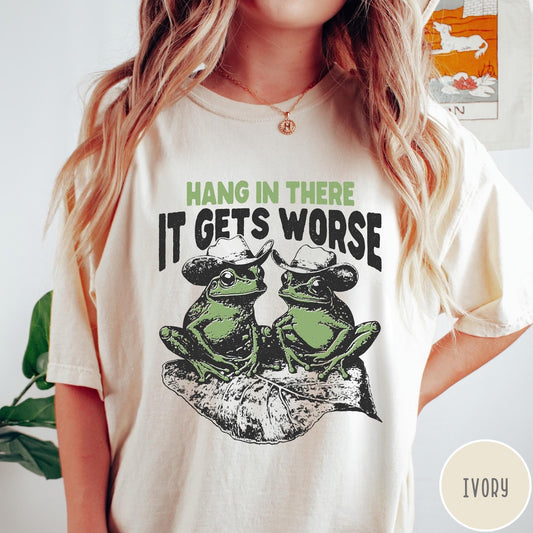 Comfort Colors tee in Ivory featuring vintage style graphic of two frogs wearing cowboy hats on leaf