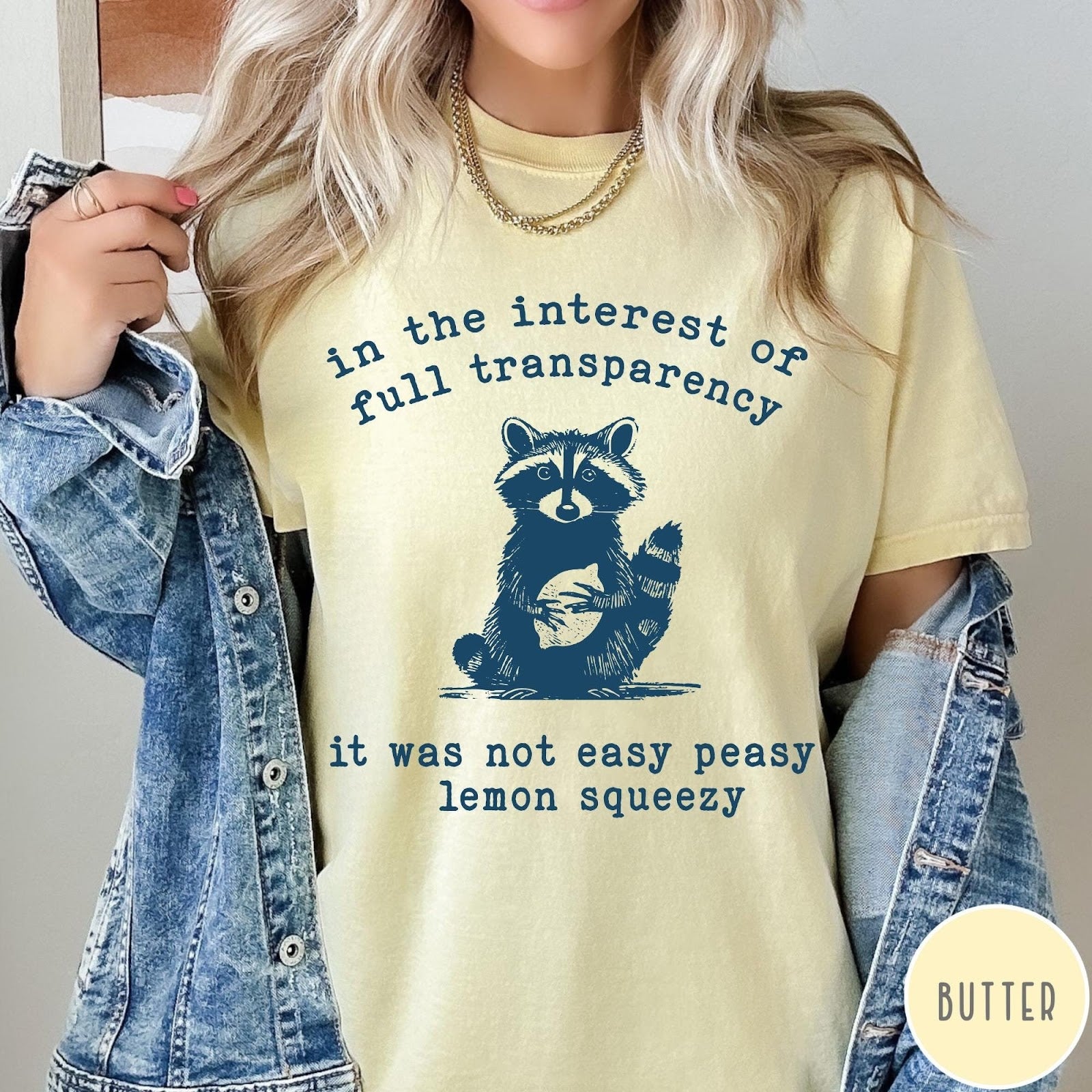 Comfort Colors tee in Butter featuring screen printed raccoon graphic and text about full transparency and lemons