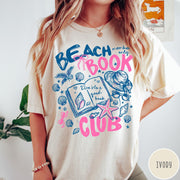 Comfort Colors tee in Ivory featuring beach book club graphic with seashells, starfish, and a sun hat