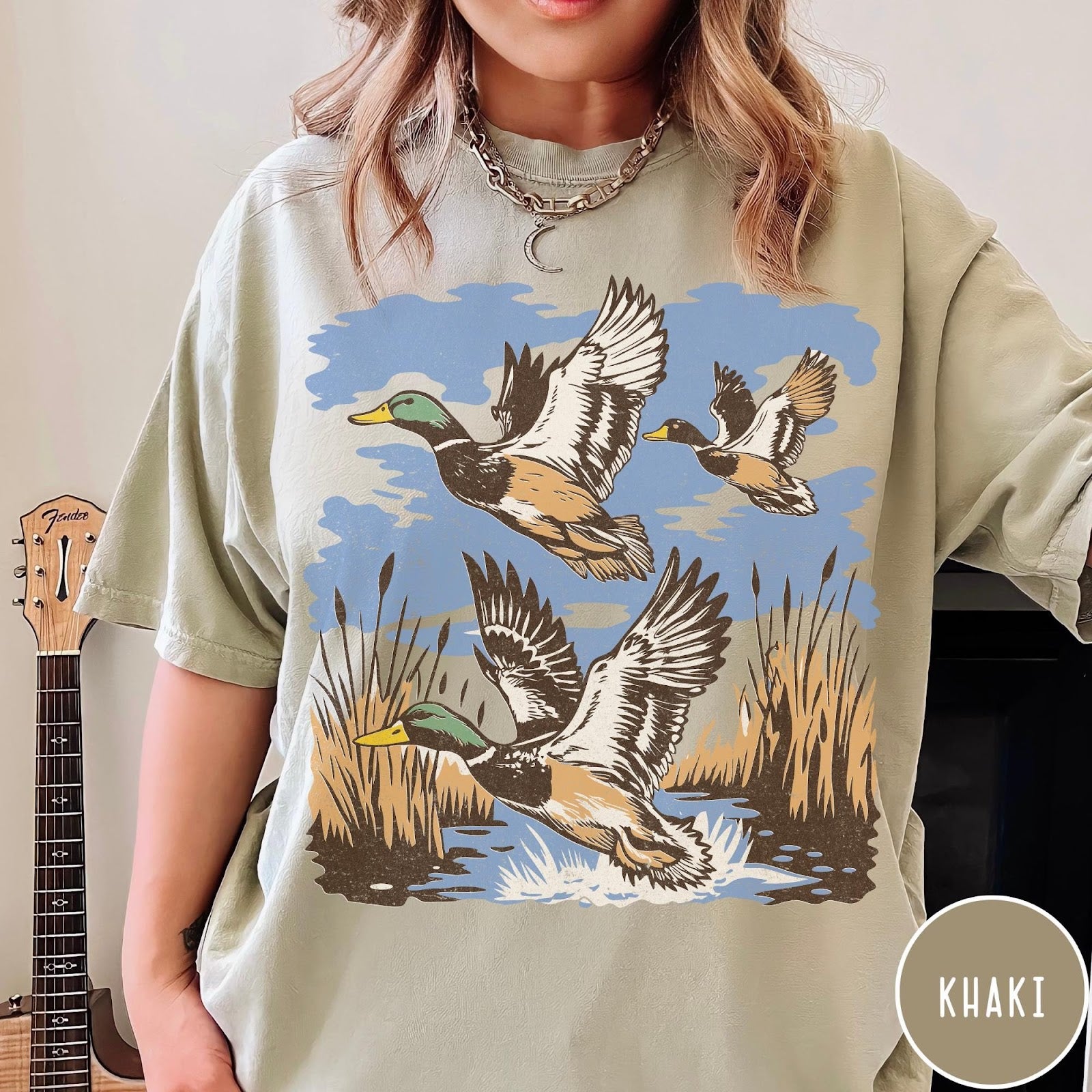 Comfort Colors tee in Khaki featuring vintage style mallard ducks flying over a marshy pond graphic