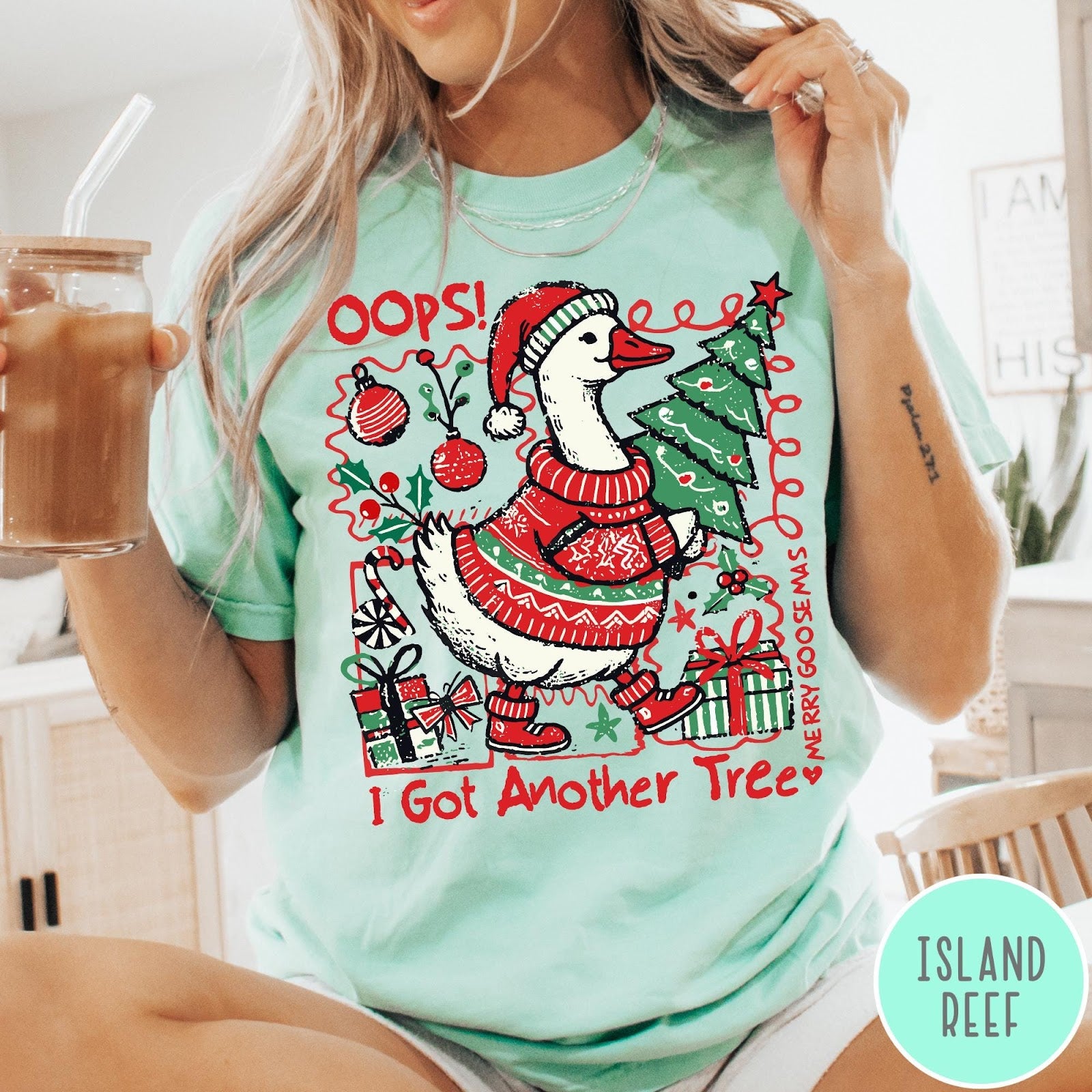 Comfort Colors tee in Island Reef featuring festive goose graphic wearing a Santa hat and Christmas sweater holding tree