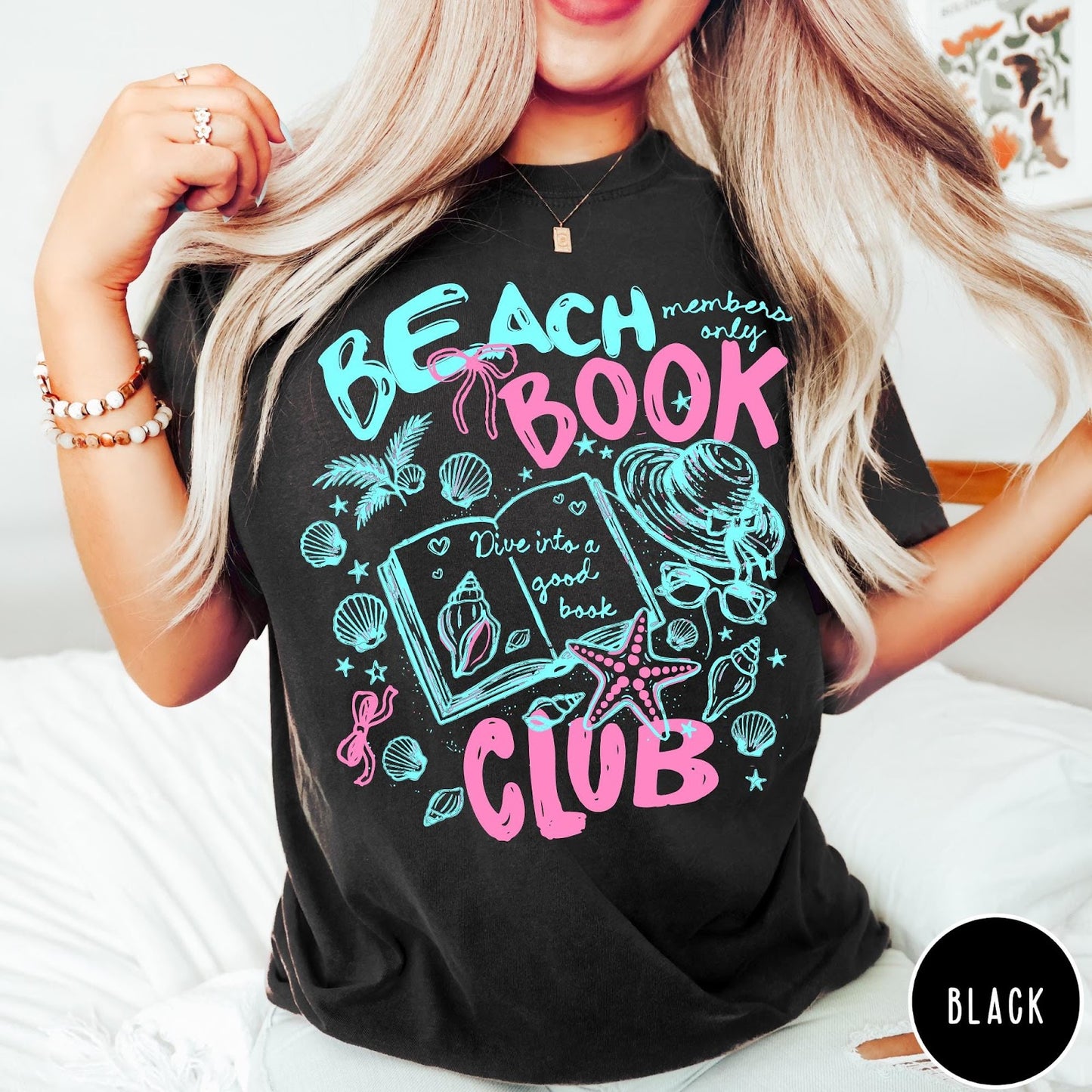 Comfort Colors tee in Black featuring beach book club graphic with open book, shells, and hat