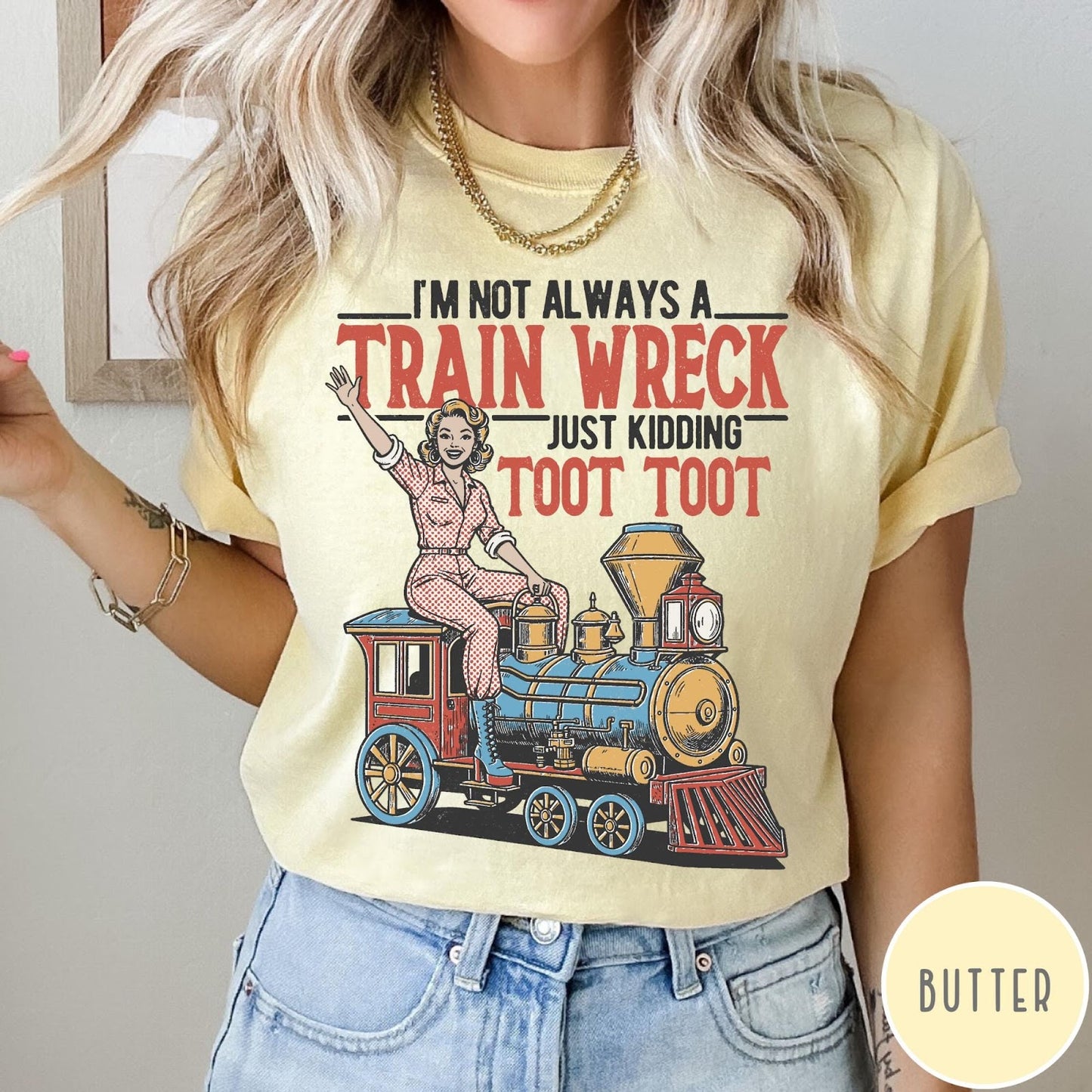 Comfort Colors tee in Butter featuring vintage style pin-up woman sitting on a steam train graphic