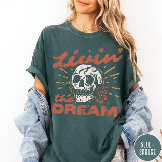 Comfort Colors tee in Blue Spruce featuring vintage style skull graphic with Livin the Dream text design