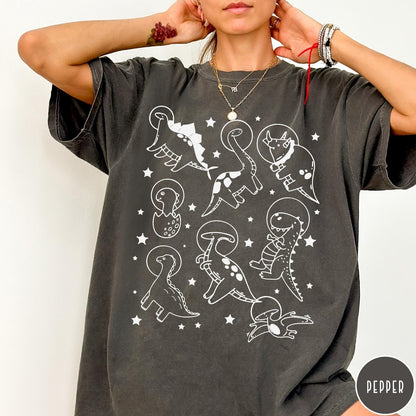 Comfort Colors tee in Pepper featuring line art graphic of various dinosaurs wearing astronaut helmets in space
