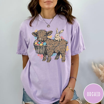 Comfort Colors tee in Orchid featuring graphic style Highland cow and bunny with an Easter egg basket