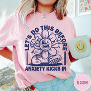 Comfort Colors tee in Blossom featuring retro graphic style winking flower character with anxiety text design