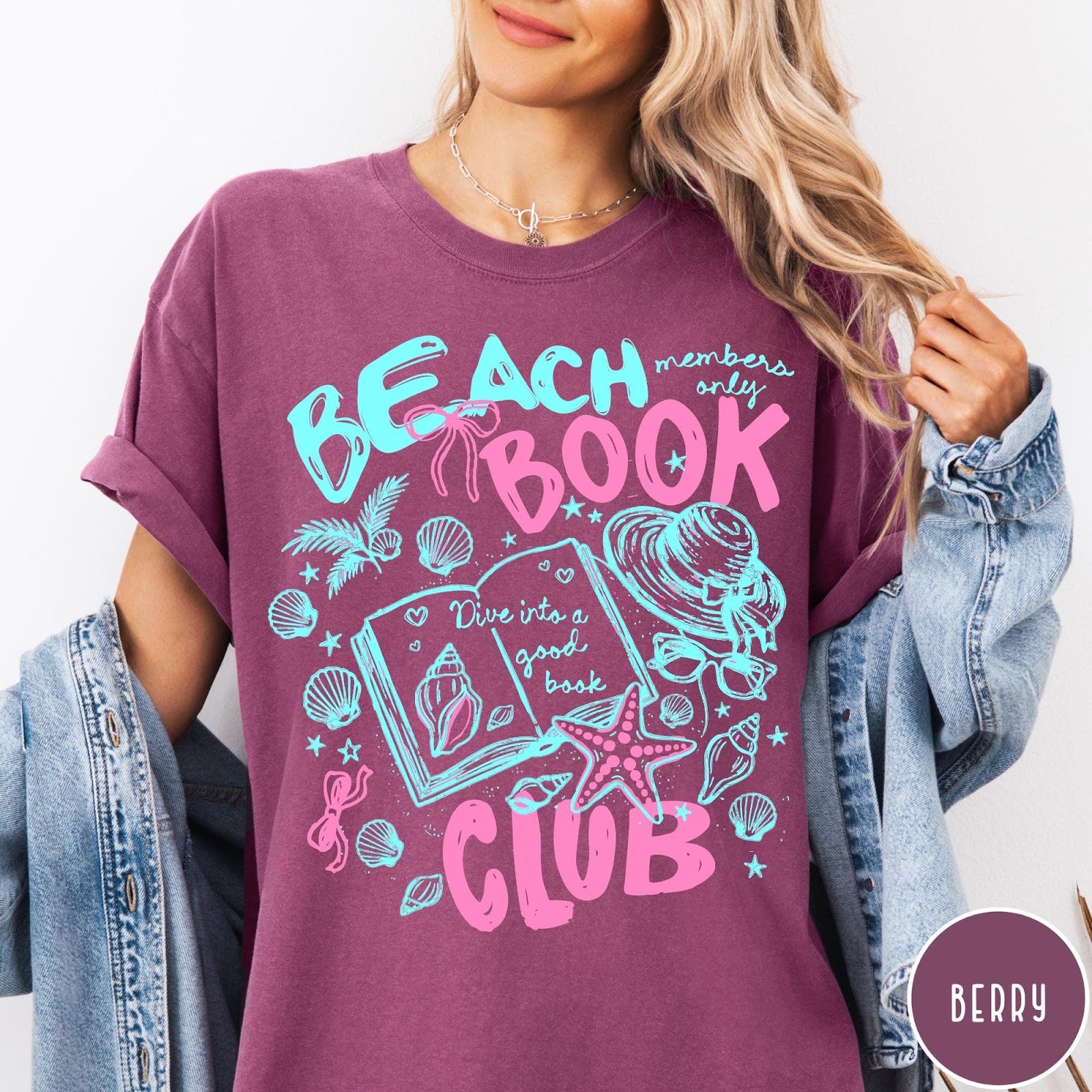 Comfort Colors tee in Berry featuring beach book club graphic with open book, shells, and hat