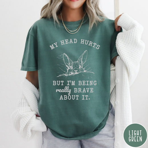 Comfort Colors tee in Light Green featuring line art graphic of a bunny resting its head on a pillow