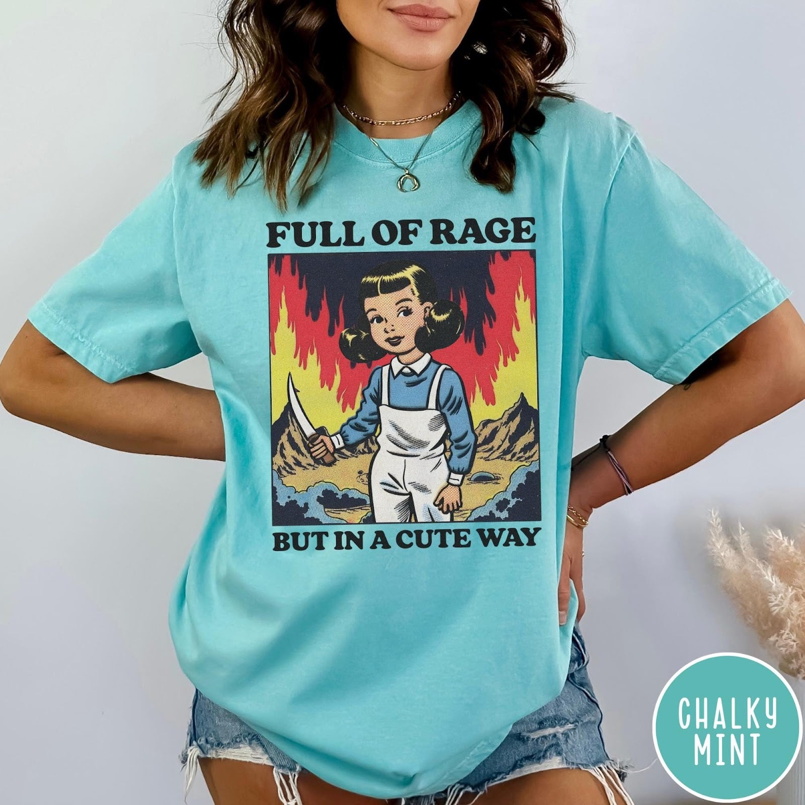 Comfort Colors tee in Chalky Mint featuring cartoon style graphic of a girl holding a knife in flames