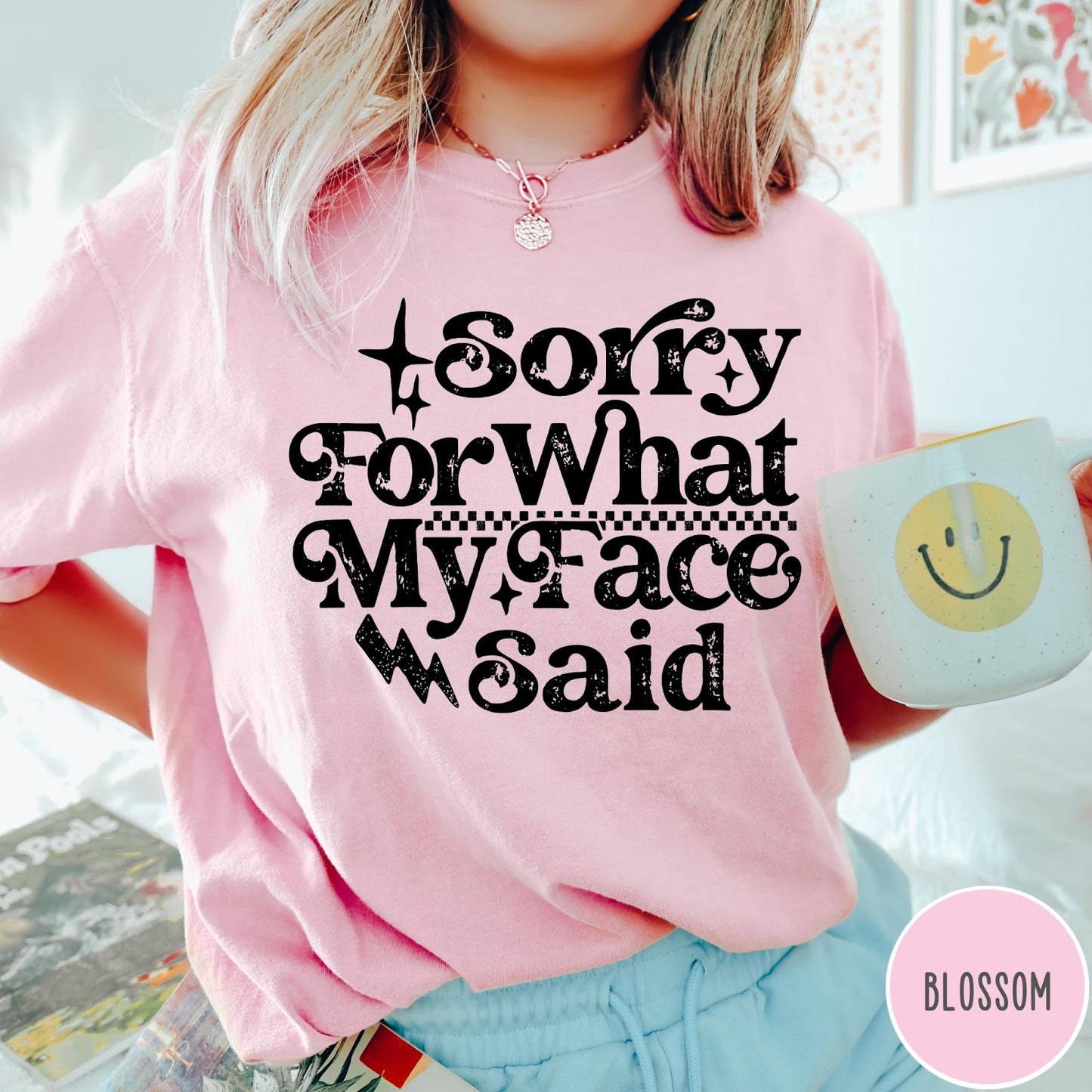 Comfort Colors tee in Blossom featuring sarcastic expression graphic Sorry for What My Face Said in black