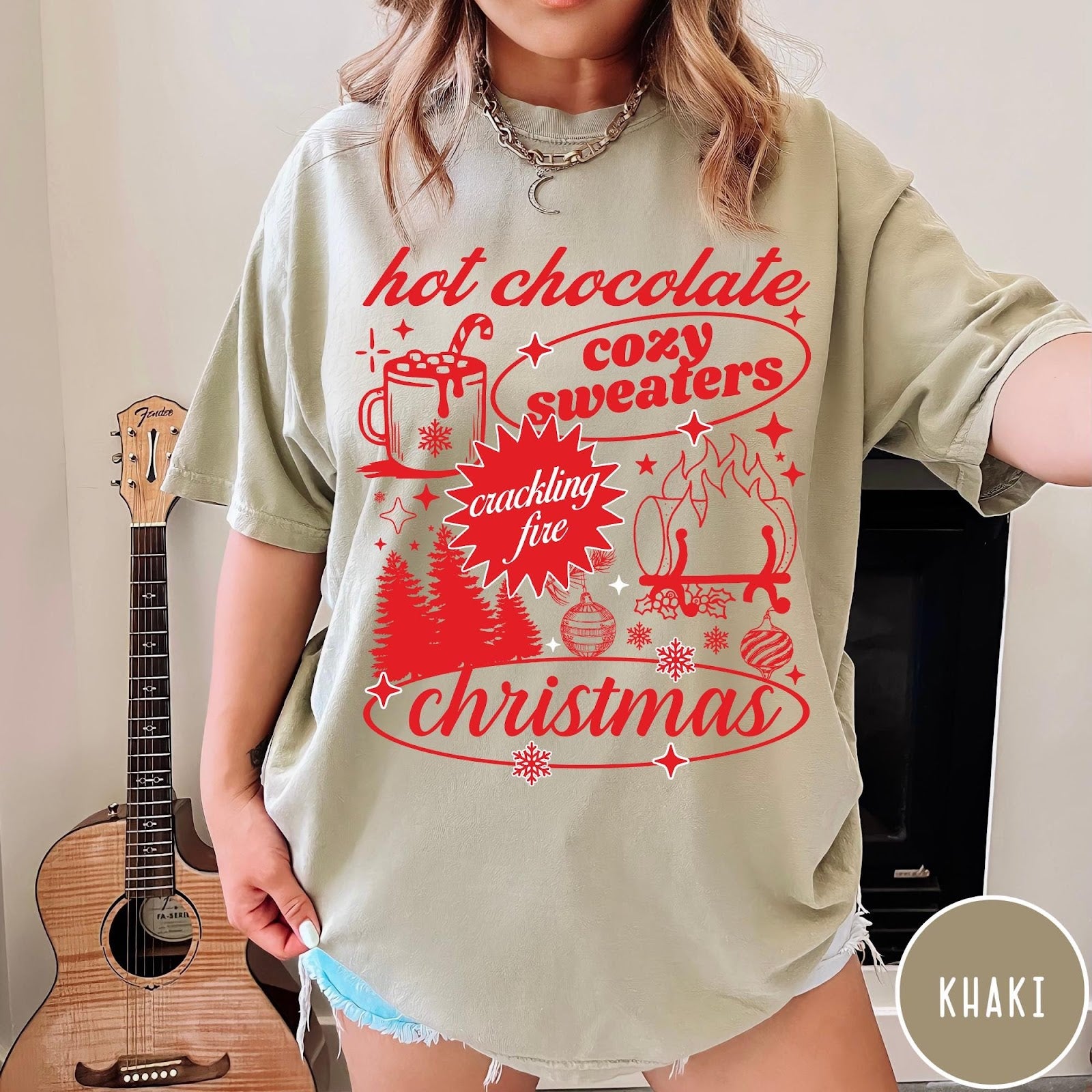 Comfort Colors tee in Khaki featuring holiday graphic design with hot chocolate, fire, and Christmas trees