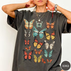Comfort Colors tee in Pepper featuring butterfly collection design with various colorful butterfly illustrations in a grid