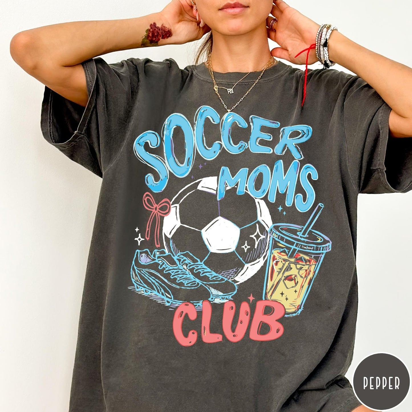 Comfort Colors tee in Pepper featuring soccer mom lifestyle graphic with soccer ball, cleats, and iced coffee