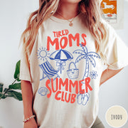 Comfort Colors tee in Ivory featuring beach vacation style graphic with sun, umbrella, palm tree, and bag