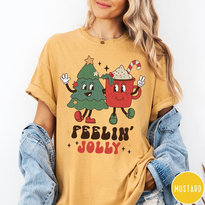 Comfort Colors tee in Mustard featuring retro graphic of a smiling Christmas tree and cocoa mug