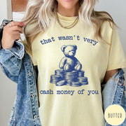 Comfort Colors tee in Butter featuring graphic style teddy bear sitting on a stack of coins