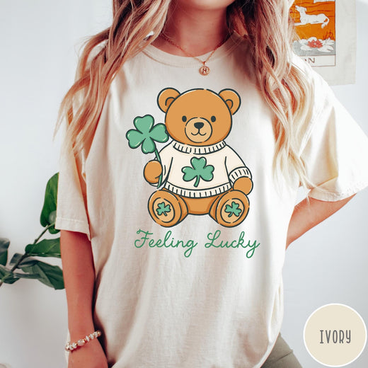 Comfort Colors tee in Ivory featuring cute teddy bear graphic wearing a sweater with shamrocks