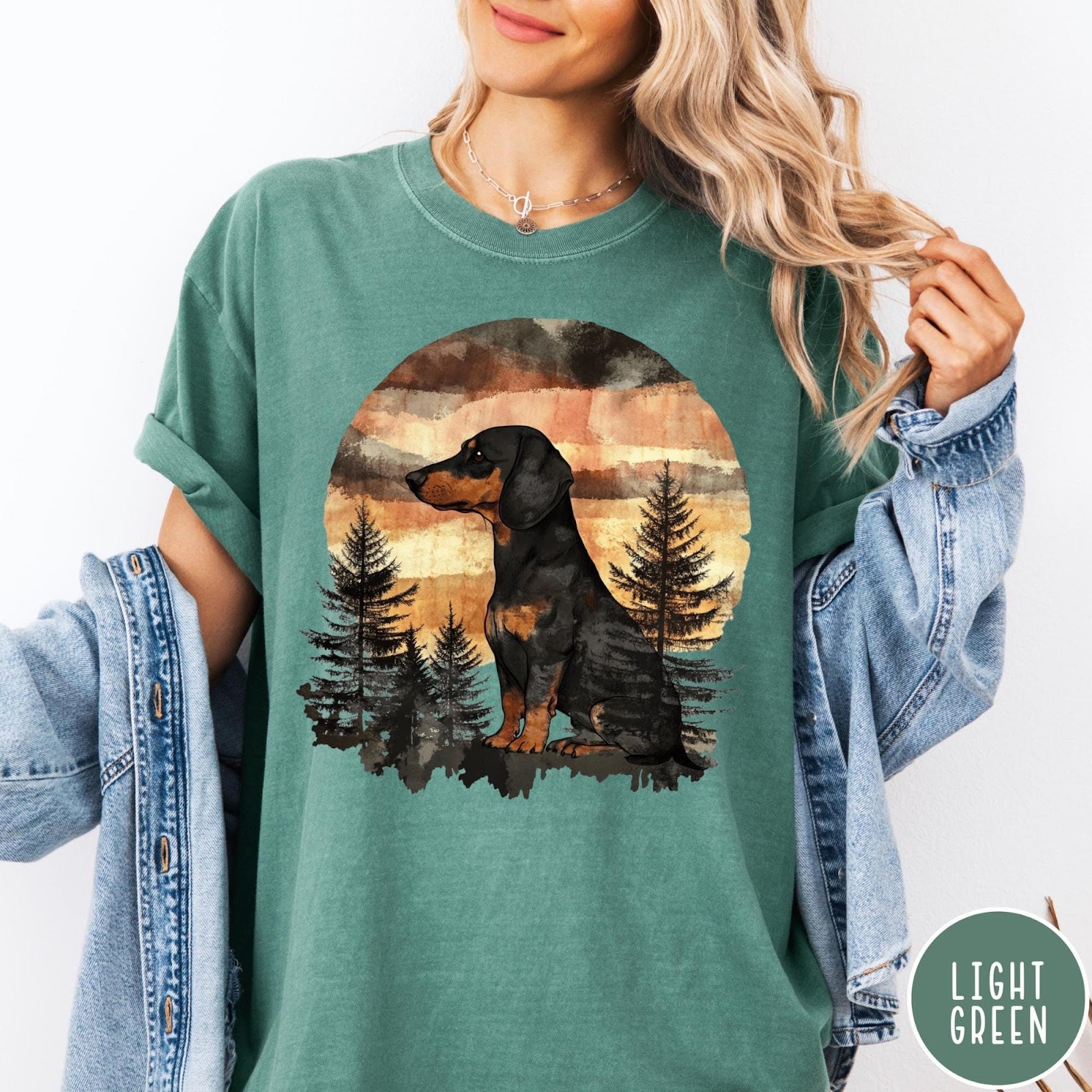 Comfort Colors tee in Light Green featuring vintage style dachshund dog graphic with forest and sunset background
