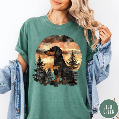 Comfort Colors tee in Light Green featuring vintage style dachshund dog graphic with forest and sunset background
