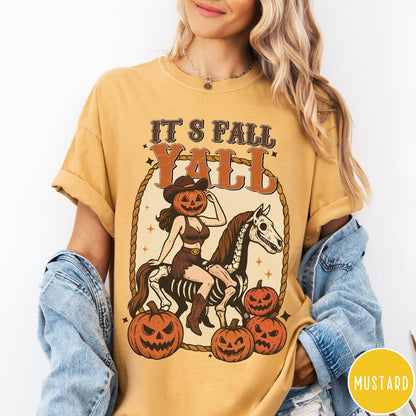 Comfort Colors tee in Mustard featuring western graphic of a pumpkin cowgirl riding a skeleton horse with pumpkins