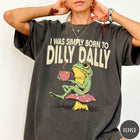 Comfort Colors tee in Pepper featuring illustrative style graphic of a frog sitting on a mushroom drinking tea