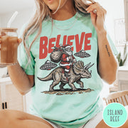 Comfort Colors tee in Island Reef featuring vintage style graphic of Santa riding a dinosaur with flying saucers