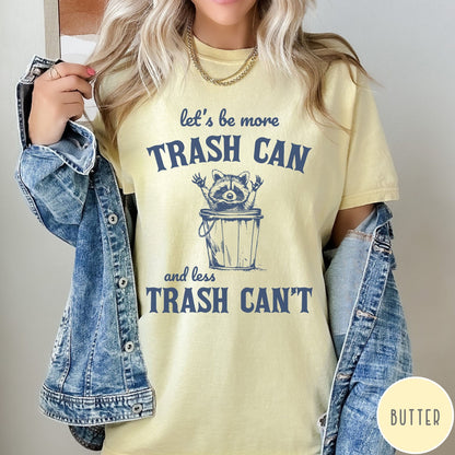 Comfort Colors tee in Butter featuring casual graphic style with a raccoon inside a trash can illustration