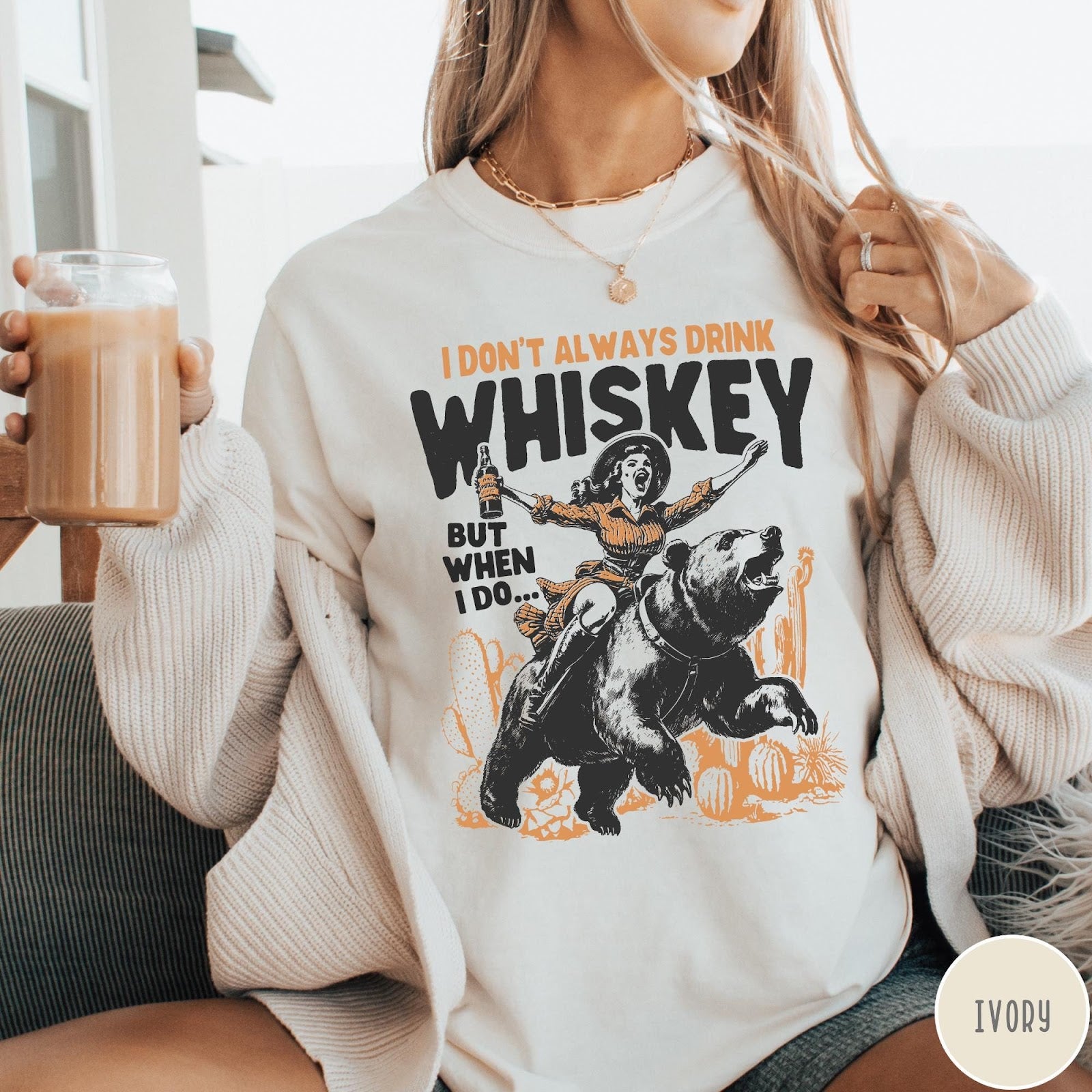 Comfort Colors tee in Ivory featuring vintage style graphic of a woman riding a bear holding whiskey