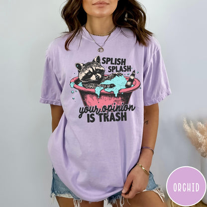 Comfort Colors tee in Orchid featuring illustrative graphic of a raccoon sitting in a pink bathtub