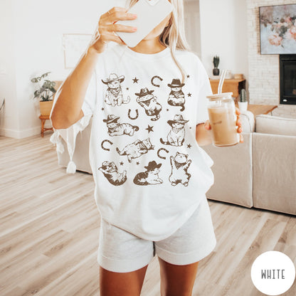Comfort Colors tee in White featuring western graphic style with multiple cowboy kittens and horseshoe illustrations