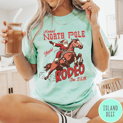 Comfort Colors tee in Island Reef featuring vintage style graphic of Santa Claus riding a bucking rodeo horse